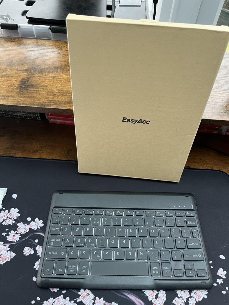 EasyAcc Bluetooth keyboard in front of the EasyAcc box on a desk mat